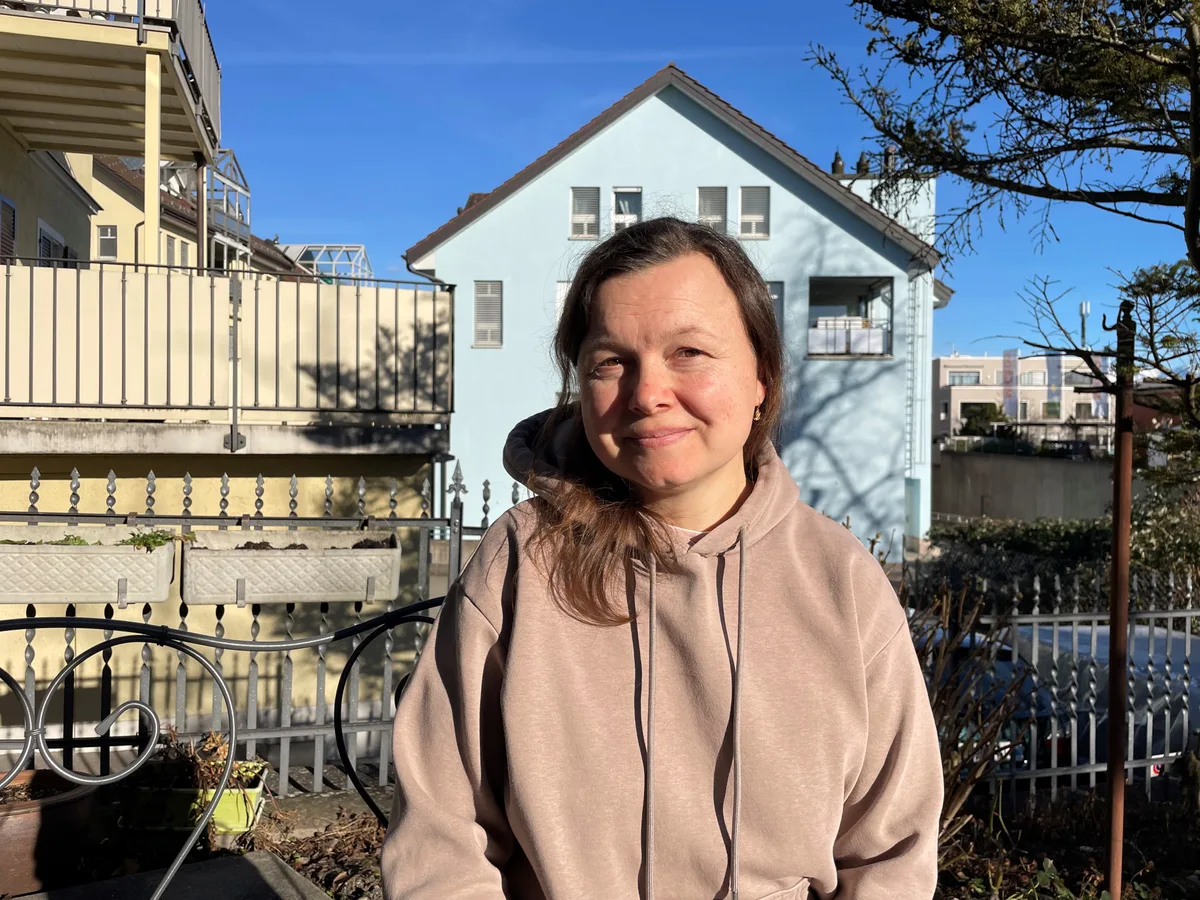 Yuliia Bezruchko plant nicht mehr lange im Voraus, sondern versucht «Tag für Tag» zu nehmen. Eine Frau sitzt im Garten auf einer Bank und schaut lächelnd in die Kamera.